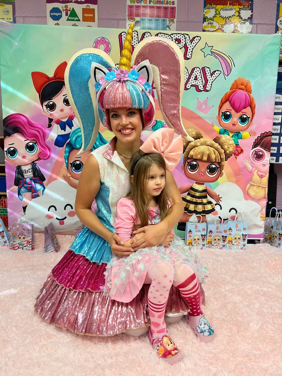 Unicorn birthday party entertainer posing with a child at a themed celebration
