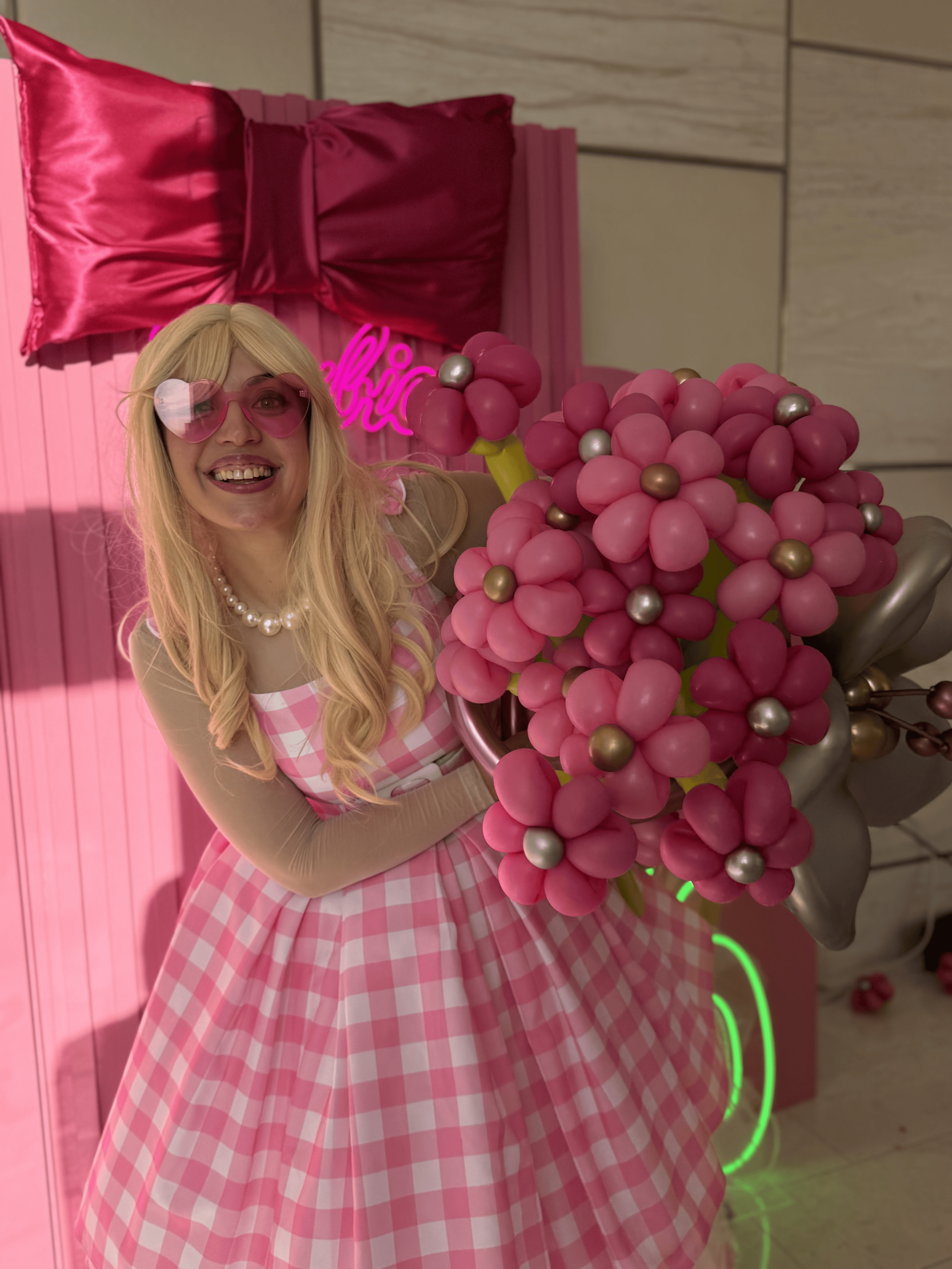 Barbie-themed entertainer holding a pink balloon flower bouquet