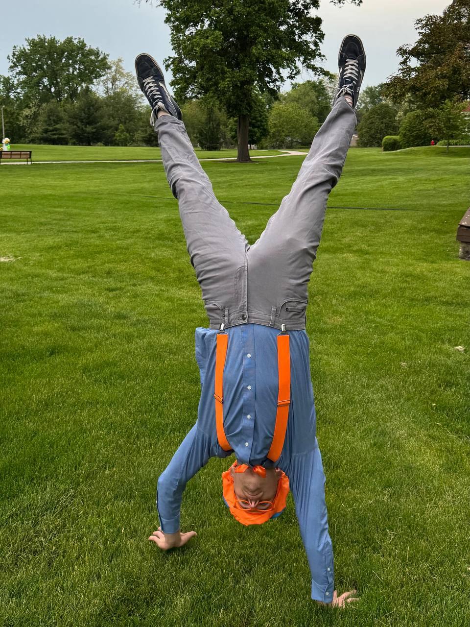 Performer doing a handstand in a Blippi-inspired costume at a kids event