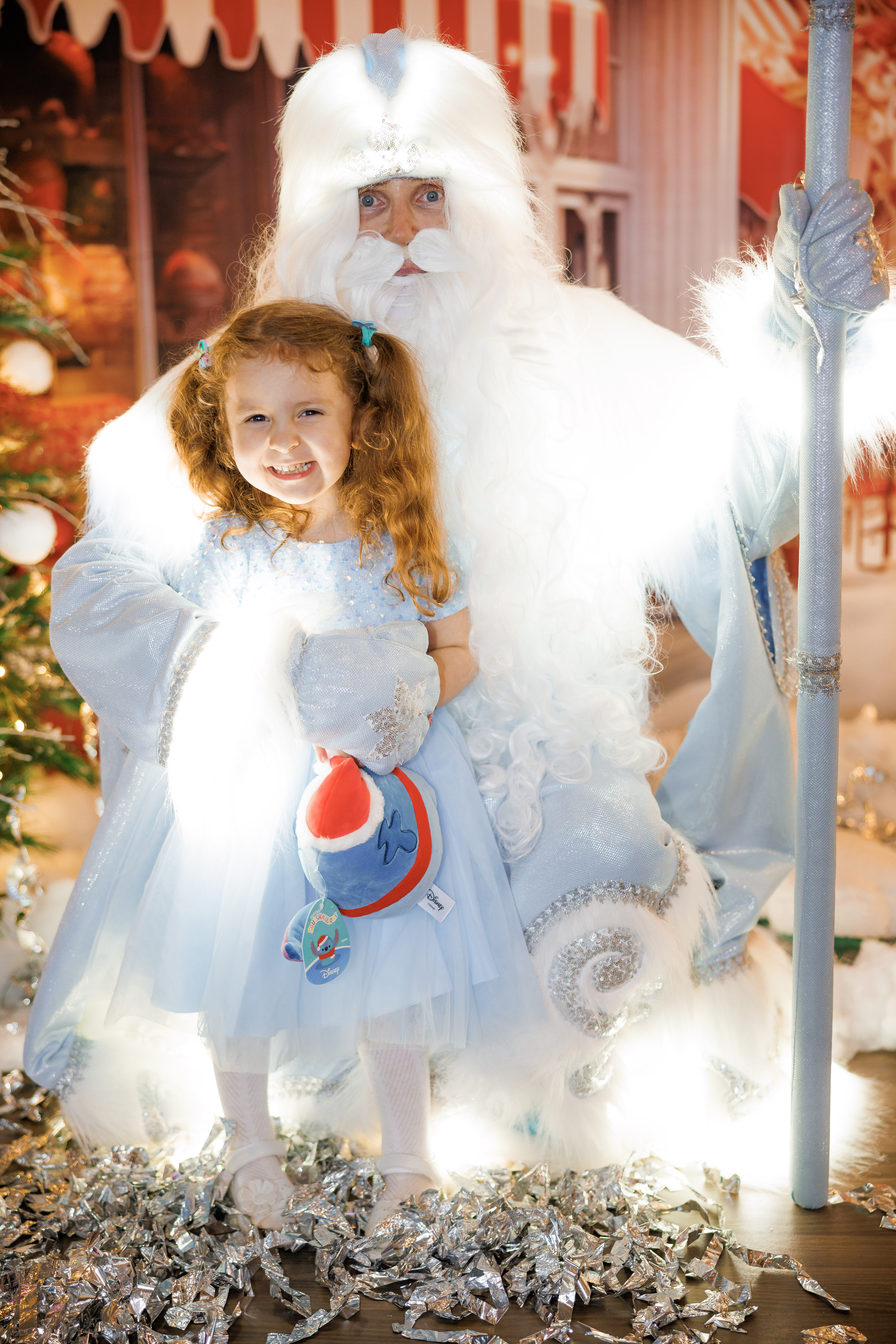 Ded Moroz character posing with a smiling girl at a Christmas event