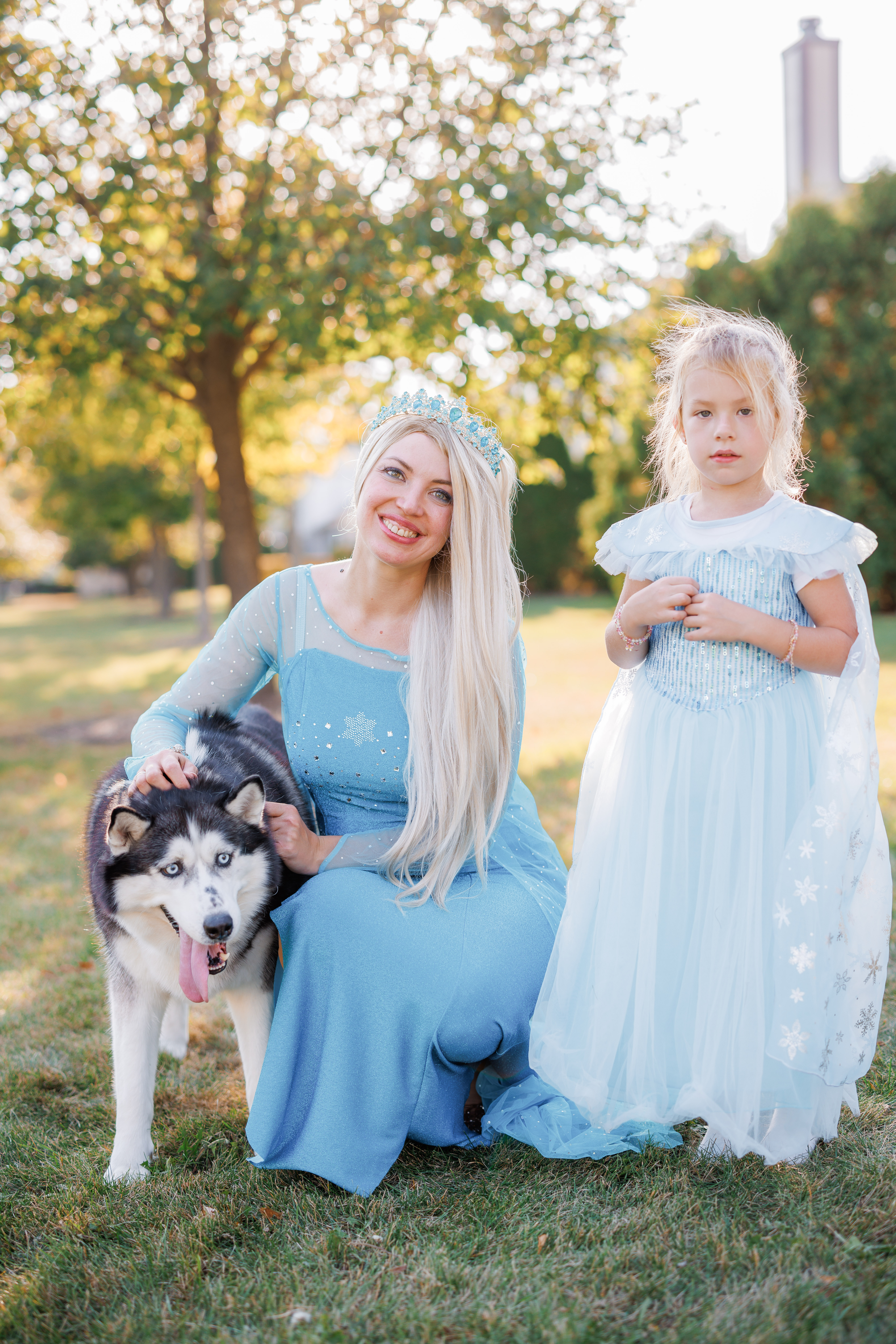 Elsa character posing with a girl and a husky dog outdoors