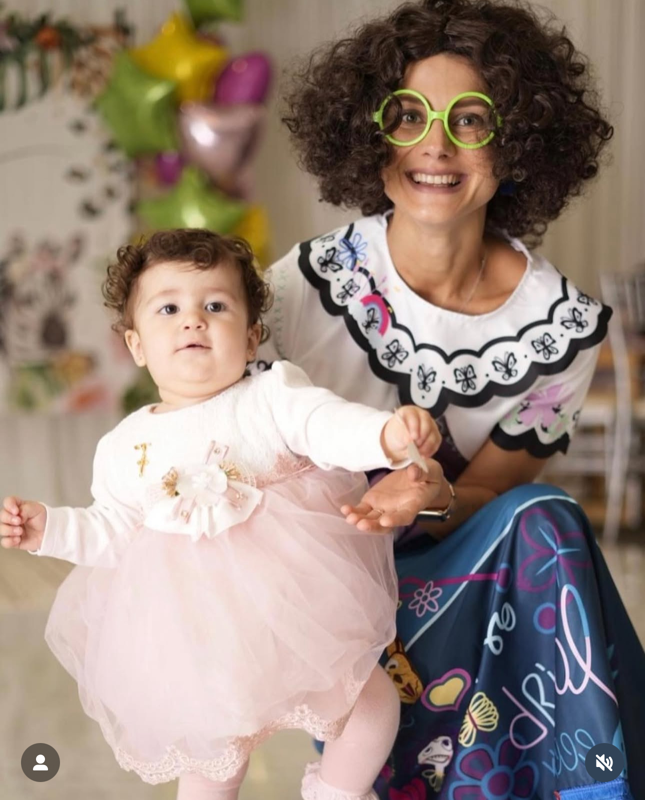 Mirabel-inspired character posing with a baby at a themed celebration