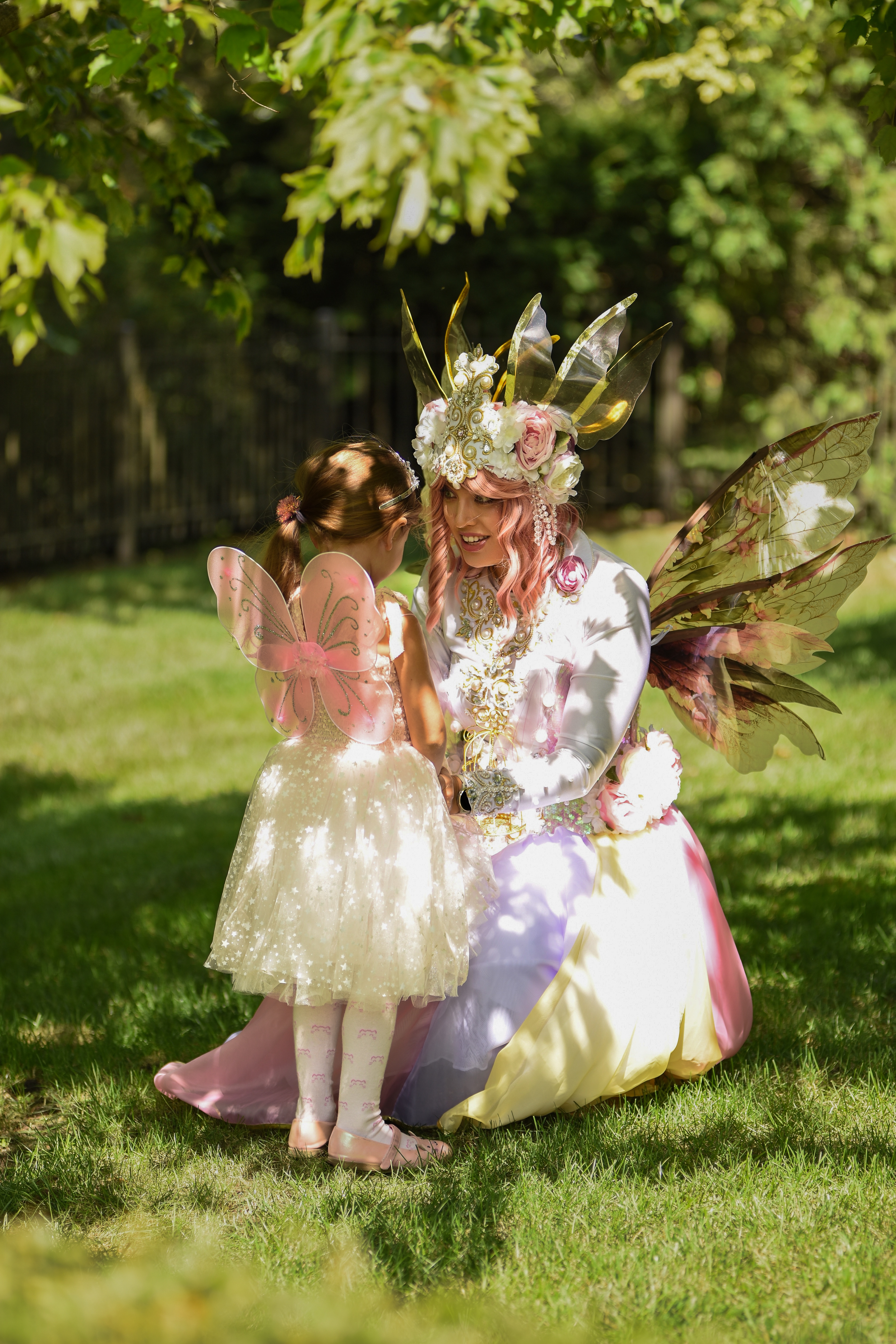 Fairy character interacting with a child at an outdoor party