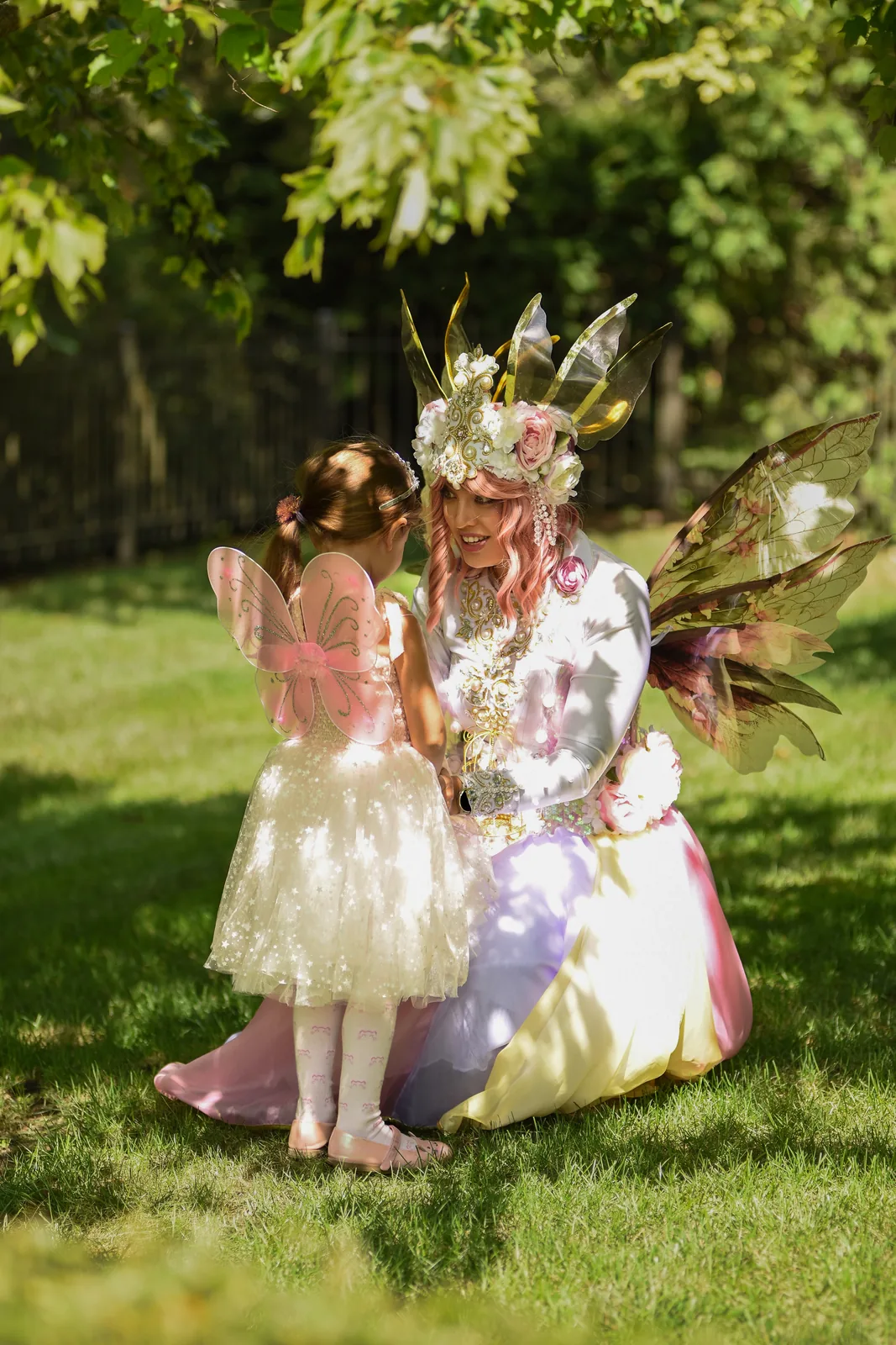 Fairy character interacting with a child at an outdoor party