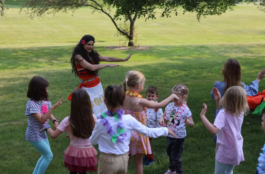 Moana party entertainer dancing with children at a tropical luau themed birthday