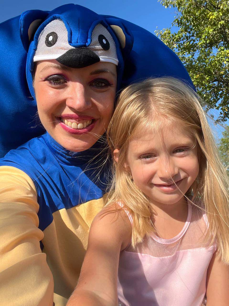 Sonic character smiling with young girl at kids party