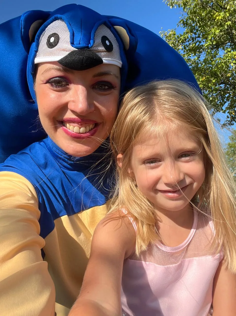 Sonic character smiling with young girl at kids party