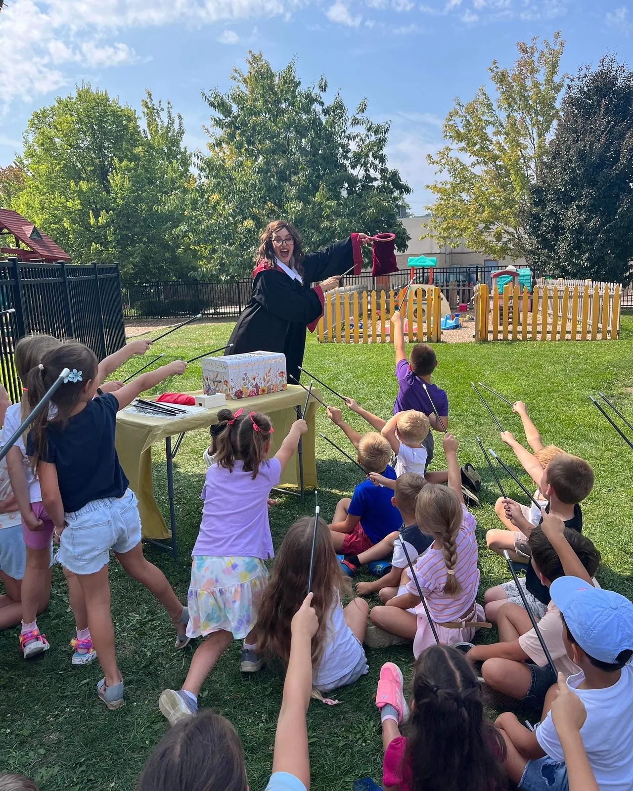 Children playing a wizard-themed game with a costumed entertainer