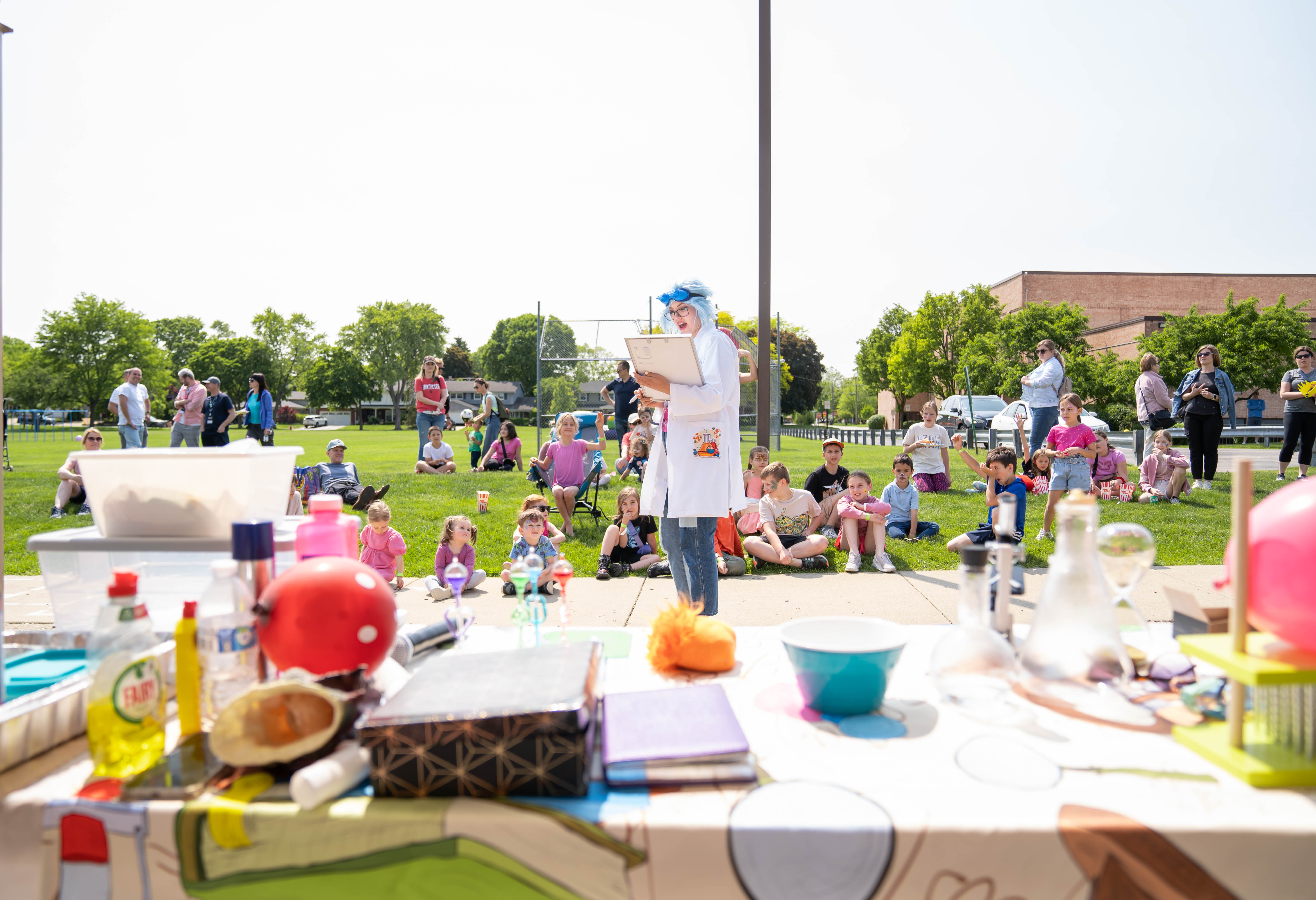 Science show performer entertaining children with a hands-on experiment