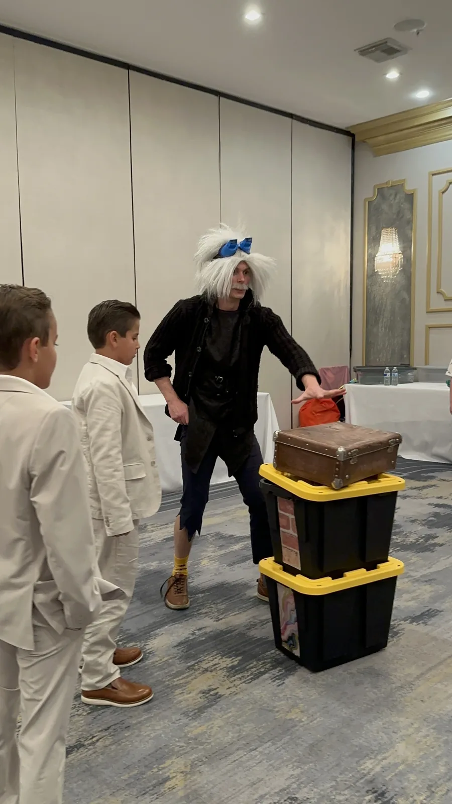 Two performers dressed in costumes entertaining children with a science act
