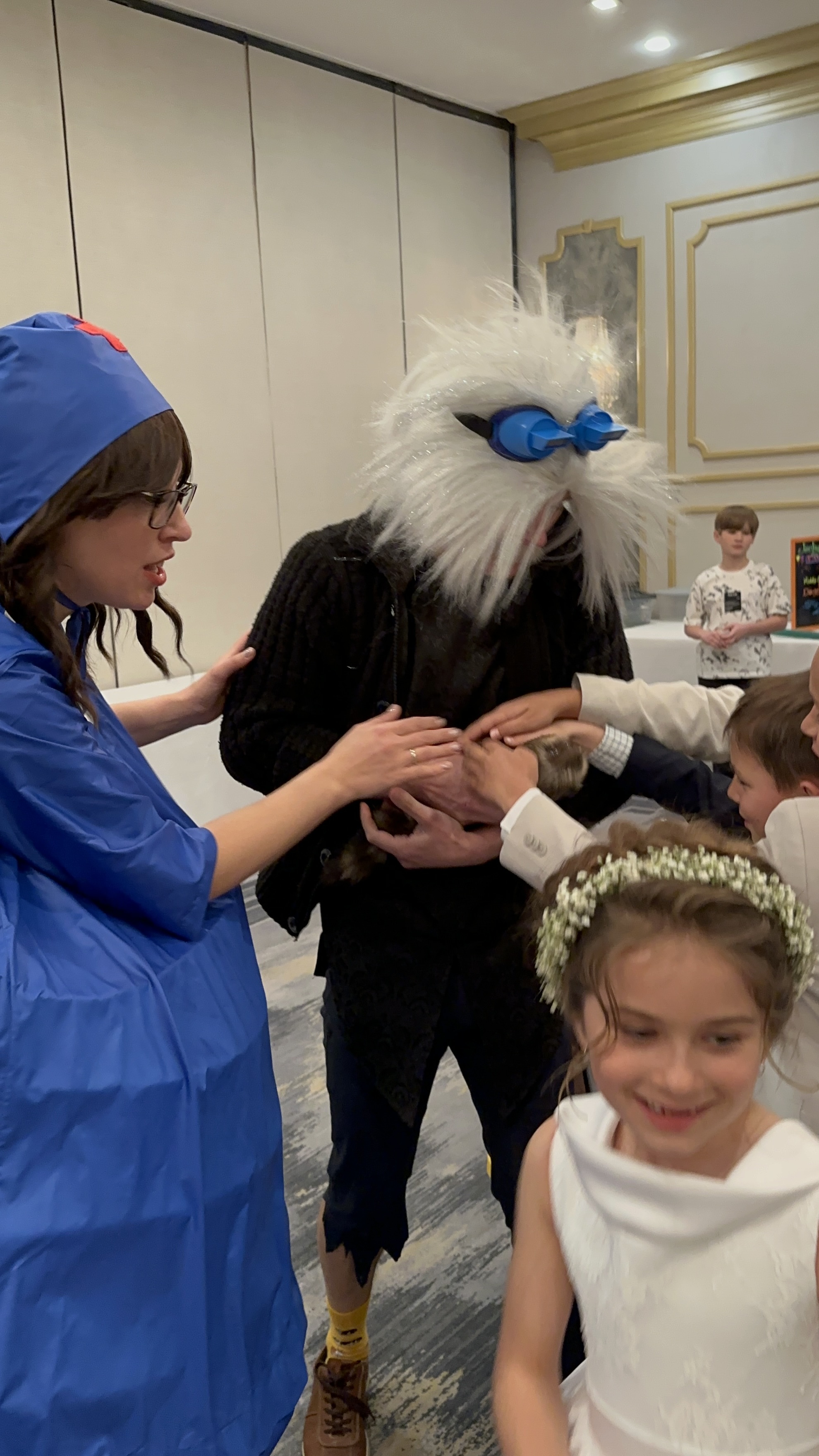 Performers and kids interacting with an animal during a children's event